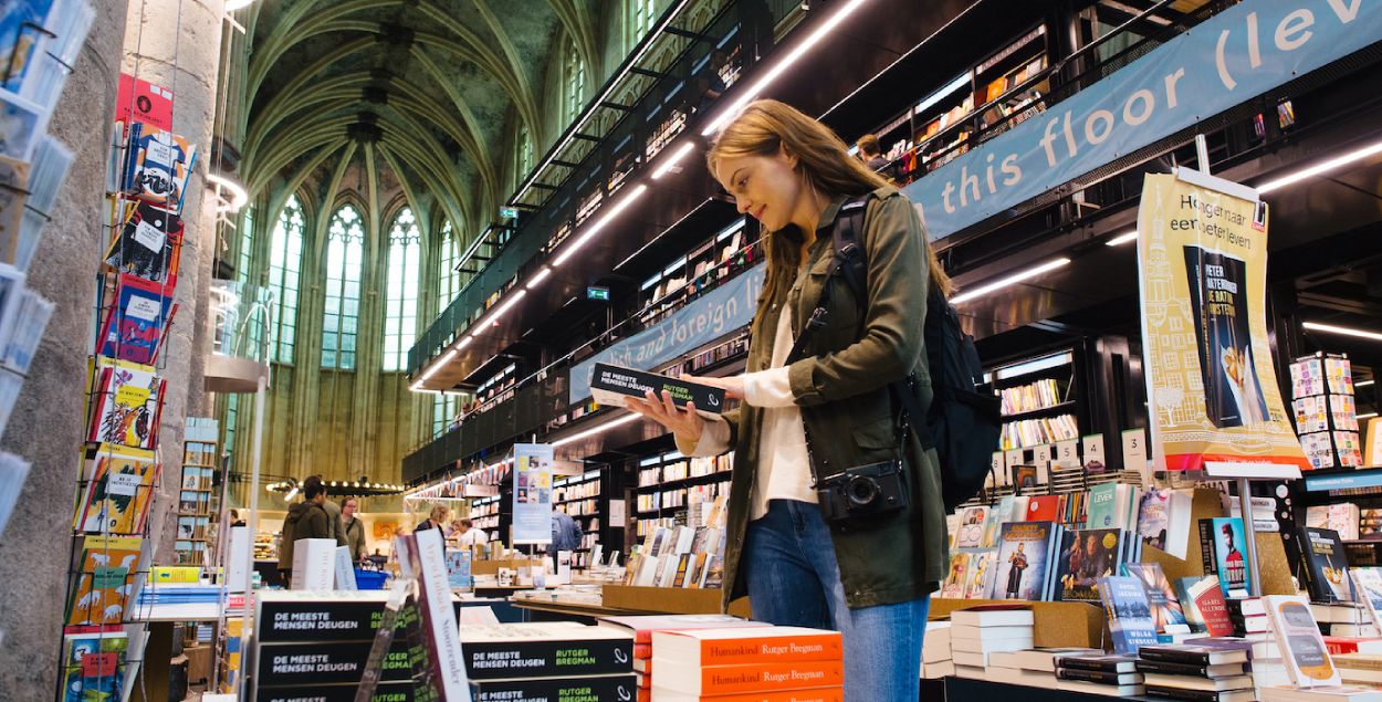 A woman reading a book in the bookstore. 